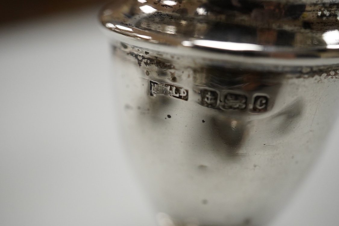 An ornate Edwardian silver oval mustard pot and matching spoon by Barker Brothers, Birmingham, 1902, length, 95mm, together with five other assorted silver condiments including a pair of pierced oval salts with blue glas